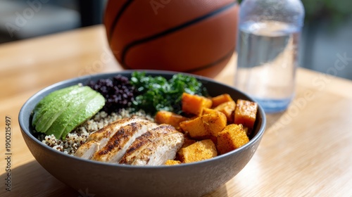 athlete nutrition plan, a nutritious pre-game meal bowl with grilled chicken, quinoa, sweet potatoes, avocado, and greens is featured