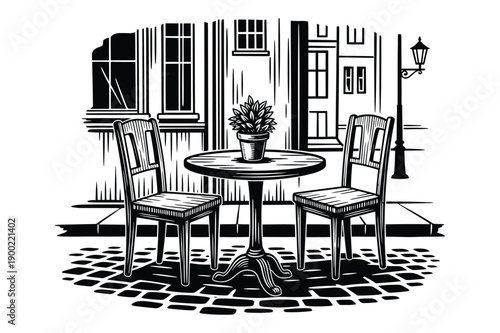 Cafe table with chairs and potted plant in front of building