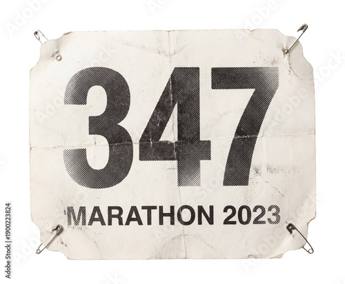 Runner bib number pinned to shirt paper sticker cutout.