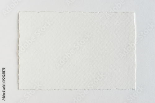 Fotografi cotton paper with torn edges on a white table