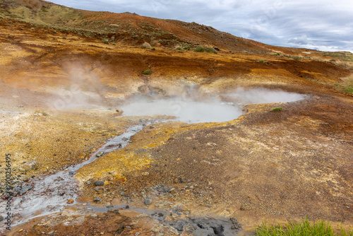 Steaming mud pot and orange sulfur soil in Seltun geothermal area Iceland.