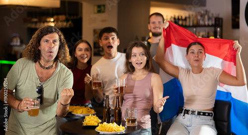 фотографія Fans of the Netherlands national team spend time in a bar, shouting chants, supp