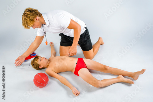 Foto Water polo coach rescuing young player after incident in the pool