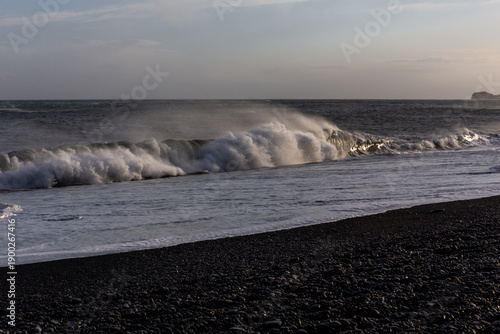 Dangerous sneaker waves crashing on Reynisfjara Black Sand Beach at sunset, Iceland