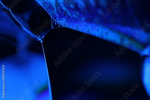 Canvas Print Abstract macro shot of blue liquid bubbles and a thin fluid thread