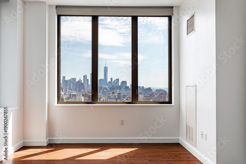 Empty apartment interior with large window and New York City skyline view