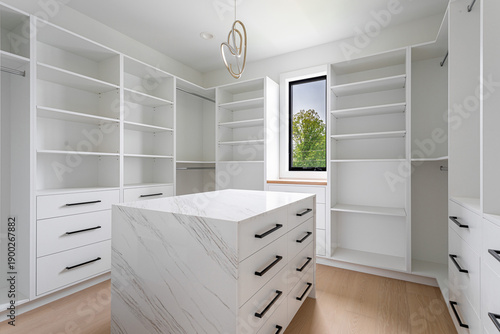 Foto Modern walk-in closet interior with built-in shelves and storage island