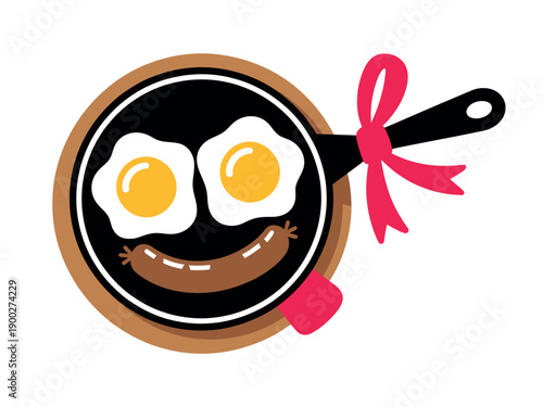 A cartoon frying pan with a smiling face made of eggs and sausage, tied with a pink ribbon.