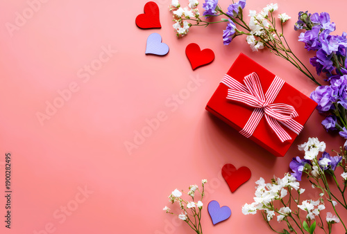 Romantic gift with hearts and flowers on pink background.