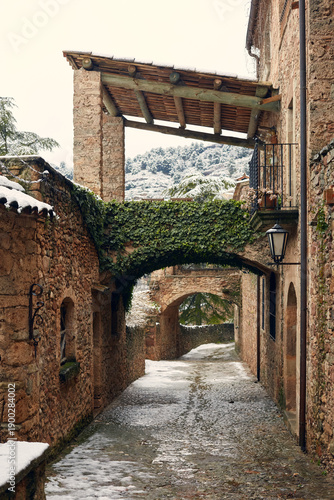 Snowy cobblestone street in Mura village, Catalonia