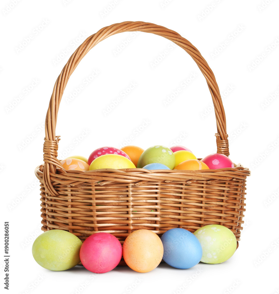 Fototapeta premium Painted Easter eggs in wicker basket isolated on white