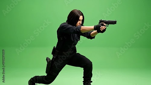 A determined figure poses dramatically with a firearm on a green backdrop.