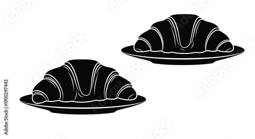 Two croissants on plates a striking black silhouette