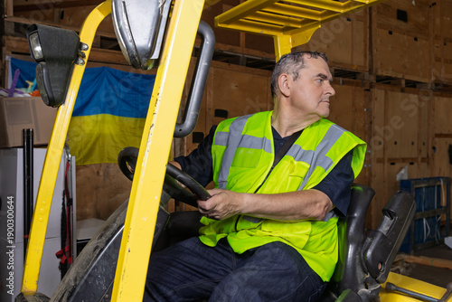 Foto Warehouse worker reversing forklift truck while looking behind