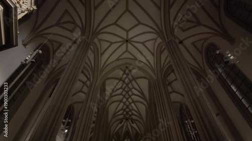 Slow motion cinematic view of the Gothic ribbed vault ceiling in St. James Church, Brno, at night