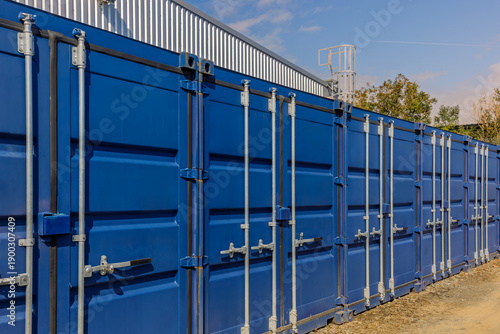Row of Blue Metal Storage Containers in Outdoor Industrial Yard