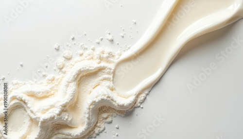 White powdered milk spills on a bright surface near a creamy liquid swirl. Dairy product with soft texture for food ads or health promotions.