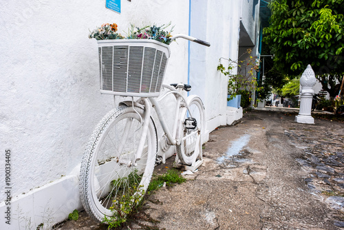 White Vintage Bicycle with Flowers against Textured White Wall in Doradal, Colombia (The Colombian Santorini)