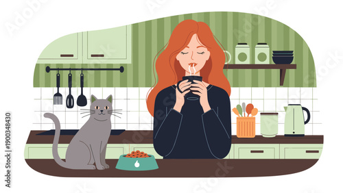 Young redhead woman enjoying a hot drink in a cozy green kitchen while her grey cat sits on the table next to a food bowl.