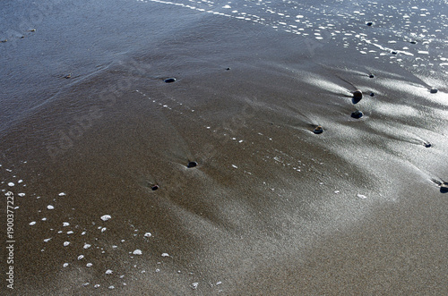 冬の浜辺。誰も居ない海を独り占めしている私。至上の解放感を味わっている。潮が引いたり寄せたり、そのたびに宝石のような小石や貝殻が、行ったり来たり波打ち際をさまよっている。眺めているだけで楽しい気分になった。幾分傾きかけた太陽の光が砂浜を照らしている。砂が作る不思議な紋様。あたかも地球上の広大な平原を眺めているようだ。時を忘れて浜辺で戯れている私。至福の時。