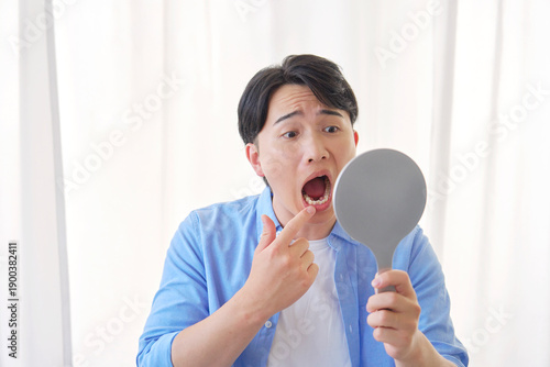 Wallpaper Mural 鏡を見る虫歯に悩む男性　20代 Torontodigital.ca