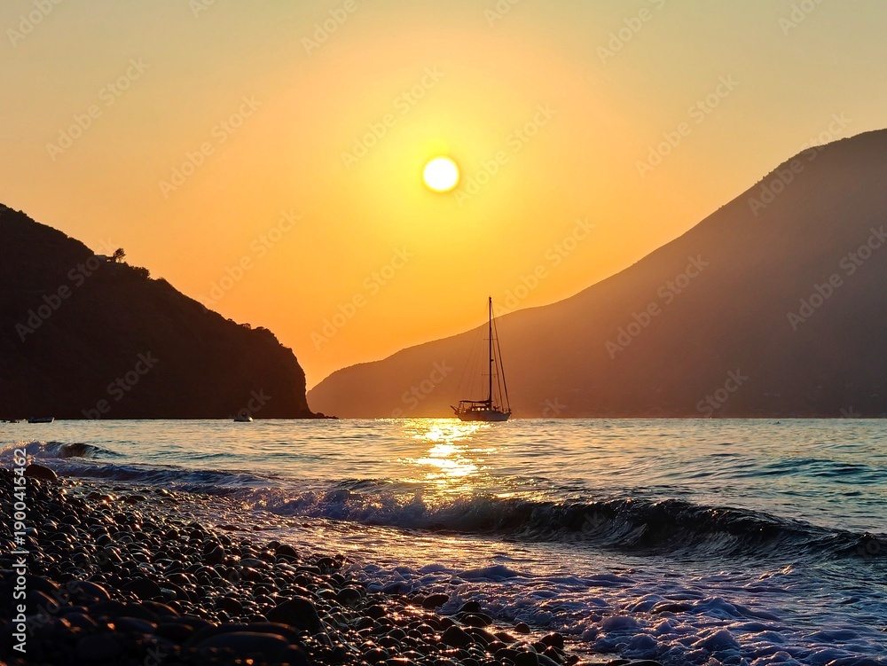© Cristiano - Sunset over the sea with a sailing boat and distant islands, golden sky and reflective water