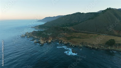 Wallpaper Mural Aerial view of Big Sur California coastline with dramatic cliffs winding coastal highway and deep blue Pacific Ocean captured in soft light creating cinematic landscape scene. Torontodigital.ca