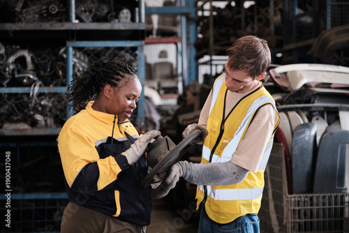 Bild auf Leinwand White male worker checks auto spare parts stock storage with Black female inspector at stack warehouse, working labor job in manufacturing factory, and industrial occupation for distribution business