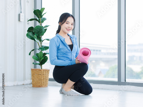 Free Download Asian young beautiful happy smiling cheerful woman active sport in sportswear sitting holding a yoga mat prepare exercise pilates stretching training in bright fitness gym healthy wellness lifestyle. - GFXLoad