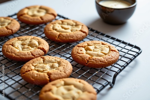 Wallpaper Mural Golden brown cookies sit to cool on a black wire rack, sprinkled with homemade cookie crumbs, with a bowl of milk in the background, giving it a homemade dessert feel. Torontodigital.ca