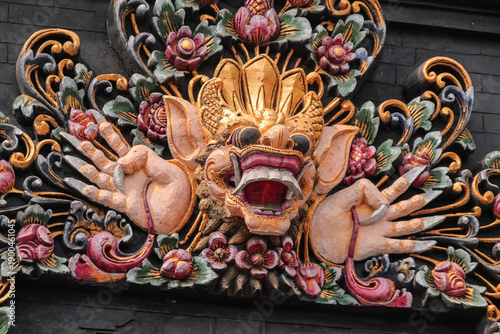 Intricate Balinese stone carving of Boma deity with floral details for cultural tourism concept