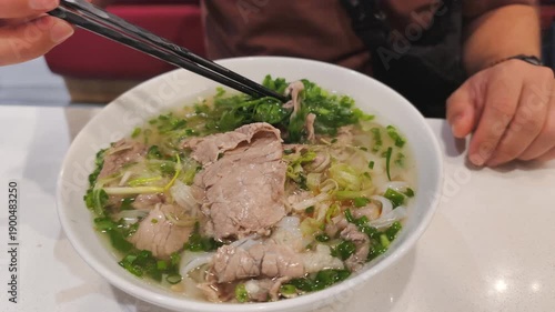 Fatty Pho Bo with rich bone broth is very filling meal. Hot Fatty Pho Bo has sliced oily beef and rice noodles. Traditional Fatty Pho Bo is nutritious asian soup for lunch in local restaurant.