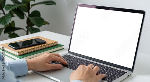 Person Typing On Laptop Computer With Mobile Phone And Books On Desk