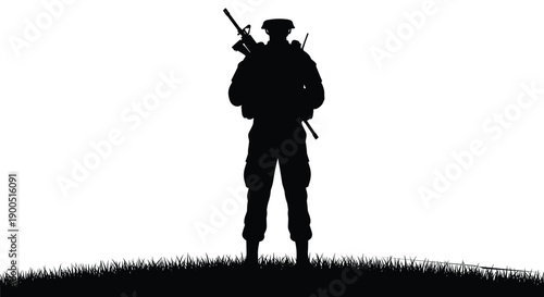 Silhouette of a lone soldier standing on a grassy hill at sunset holding a rifle and gear for military concept