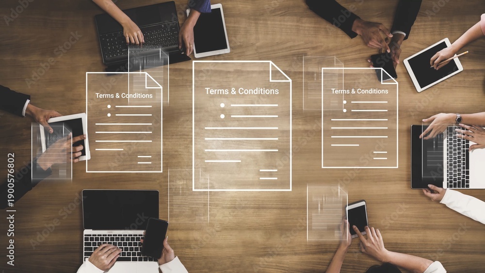 Naklejka premium Hands Collaborating on Digital Devices to Review Terms and Conditions on a Modern Office Table Surrounded by Documents and Technology Gluon.