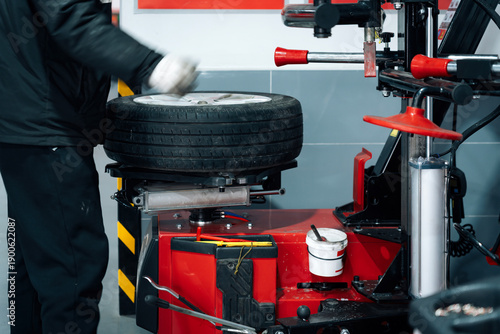 Mechanic Using Tire Changer Equipment in Auto Repair Shop