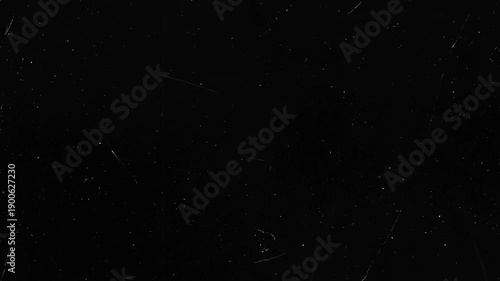 Black surface with scattered white dust and linear scratches