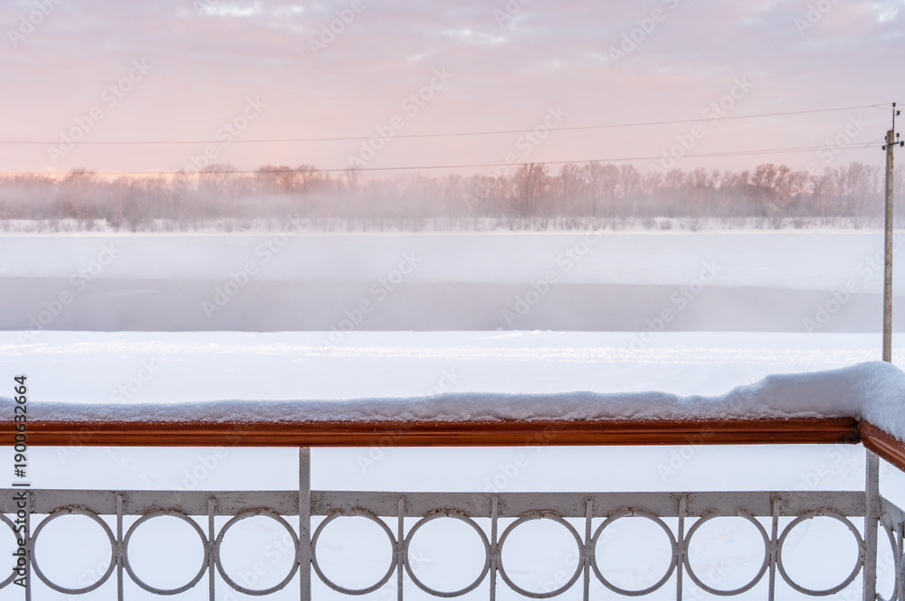 Fototapeta premium Snow on the balcony railing after heavy snowfall on background of winter dawn. 