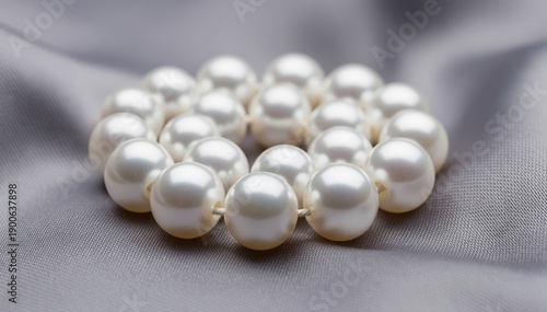 Luminous Pearls: A captivating close-up of a string of lustrous pearls arranged elegantly on a delicate, textured surface. Showcasing the timeless beauty and classic charm of these natural gems.