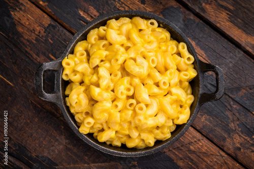 Creamy mac and cheese in a cast iron skillet on rustic wooden table — comfort food shot.