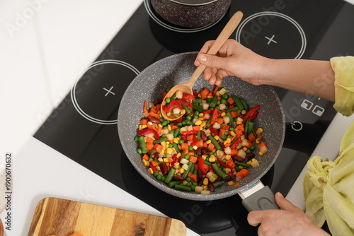 Woman with spoon frying veg...