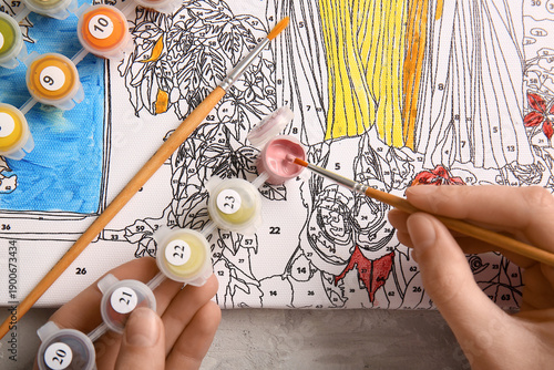 Woman paints on canvas for ...