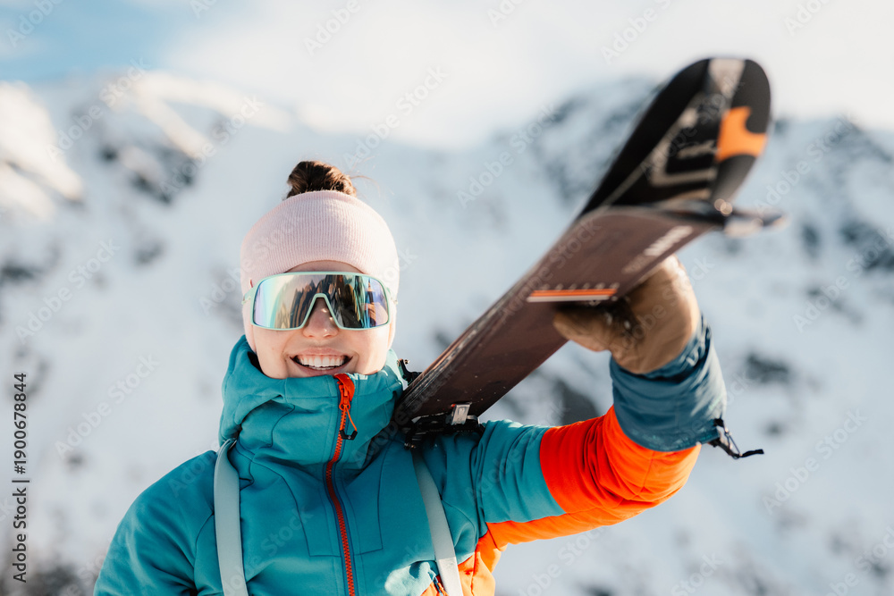 Obraz premium Ski alpinist in the mountains. Ski touring in alpine landscape. Adventure winter sport. Low Tatras, slovakia Woman holding skis in her hand