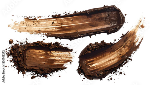 Brown makeup swatches, smears, and powder, capturing texture and depth against black