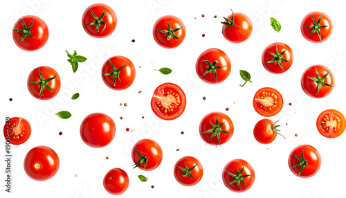 Overhead view of ripe red tomatoes, some sliced, with green leaves, arranged on black