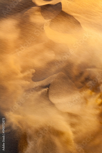 Sandsturm in den Sanddünen der Wüste Gobi, Mongolei, mit durch den Wind aufgewirbelte, über den Boden fliegende Sandkörner
