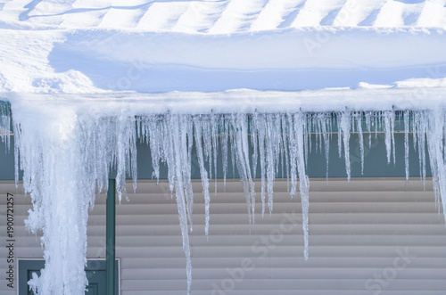 Φωτογραφία winter house with icicle and snow on the roof