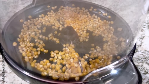 Corn evenly spread in popcorn popper before popping