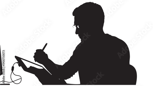 Man working on digital tablet in silhouette with stylus pen in creative workspace for graphic design