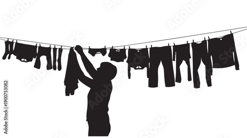 Silhouette of a person hanging laundry on a clothesline.